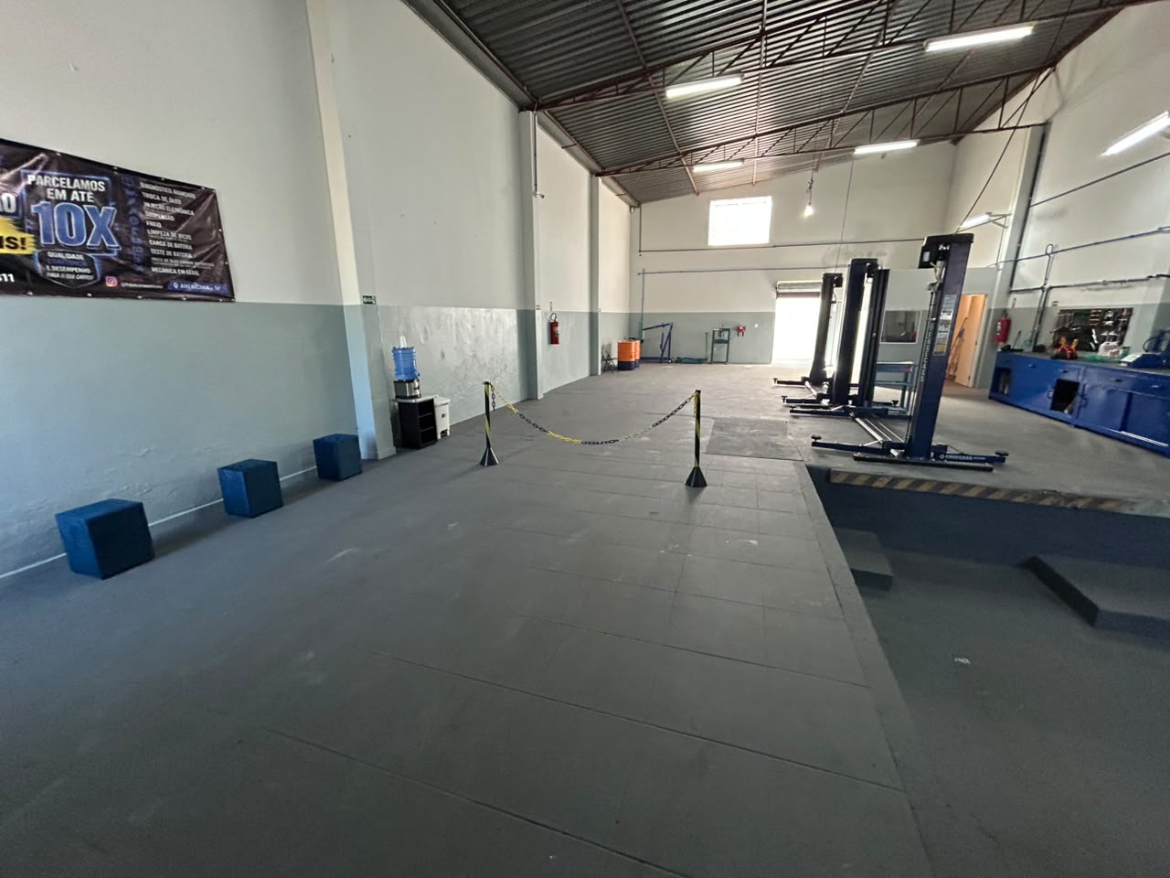 Interior da oficina PointCar com elevadores automotivos e bancadas de ferramentas